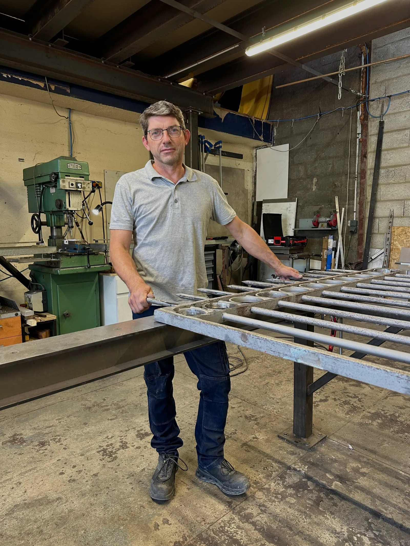 Gilles Antigny, artisan métallier et fondateur de L'Atout Faire, façonnant une pièce de métal à froid